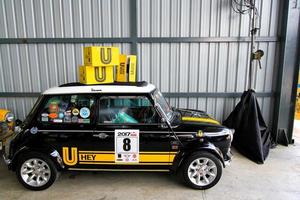 bangkok, thaïlande - 29 janvier 2023 mini austin classique bleu, jaune et noir parking dans garage avec boîte jaune sur le toit supérieur et fond de mur de zinc dans un style de couleur vintage. petit véhicule photo