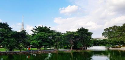 beau parc verdoyant avec lac, arbre, pagode blanche, nuages et fond de ciel bleu. belle dans la nature, lieu de détente et environnement dans le concept de ville urbaine photo