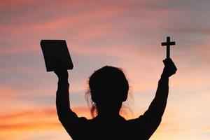 femme avec croix et bible dans les mains priant pour la bénédiction de dieu le matin, spiritualité et religion photo