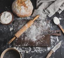 pain cuit au four, farine de blé blanc, rouleau à pâtisserie en bois photo