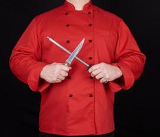 chef en uniforme rouge aiguise un couteau photo