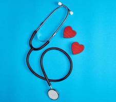 stéthoscope médical noir et coeur rouge en bois photo