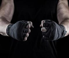 les mains des hommes enveloppées dans un bandage noir photo