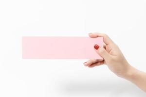 gros plan de femmes tenant du papier vierge rose sur fond blanc. photo