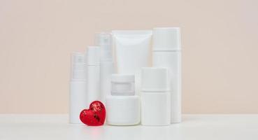 pots et tubes en plastique blanc pour cosmétiques liquides sur fond beige. image de marque, publicité photo