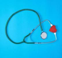 stéthoscope médical vert et coeur en bois rouge photo
