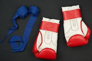 paire de gants de boxe en cuir rouge blanc et bandage textile bleu photo