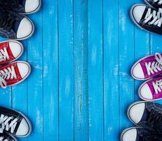 baskets colorées pour les jeunes sur fond bleu des planches de bois photo