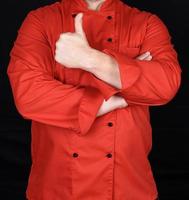 cuisinier en uniforme rouge a croisé les bras et montre un geste comme photo