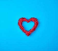 coeur rouge en osier sur fond bleu photo