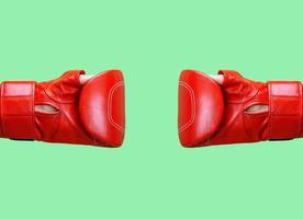deux mains féminines portent un gant de boxe en cuir rouge sur fond vert photo
