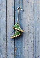 paires de vieilles baskets classiques vertes en textile accrochées à un cordon photo