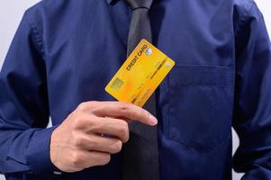 homme tenant une carte de crédit jaune photo