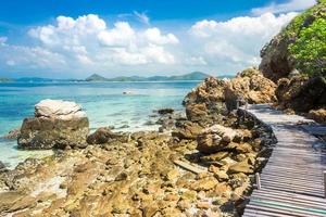 Pont de roche et de bois de l'île tropicale sur la plage avec ciel bleu nuageux