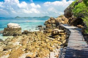 Pont de roche et de bois de l'île tropicale sur la plage avec ciel bleu nuageux
