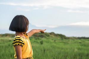 fille pointant sa main vers le ciel photo