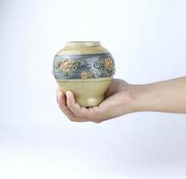 Main tenant un vase en céramique vintage isolé sur fond blanc photo