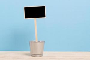 Étiquette de tableau noir dans un seau sur un bureau en bois photo