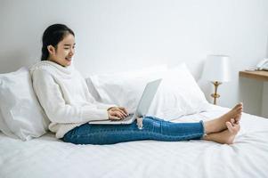 jeune femme portant une chemise blanche jouant sur son ordinateur portable