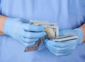 médecin en uniforme bleu et gants raconte de l'argent photo