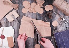 bobine de corde marron, étiquettes en papier et vieux ciseaux sur fond de bois gris photo