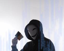 données personnelles de cartes de crédit volées par un homme anonyme en chemise à capuche noire. photo