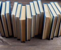 pile de livres dans une couverture bleue sur une table en bois marron photo