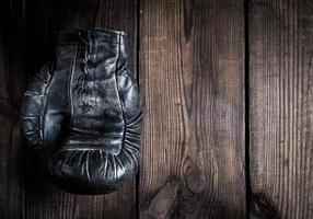 un très ancien gant de boxe noir en cuir avec lacets photo