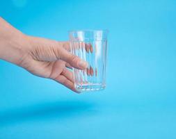 main de femme tenant un verre transparent vide photo