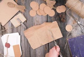 bobine de corde marron, étiquettes en papier et vieux ciseaux sur fond de bois gris photo