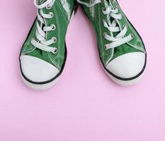 paire de chaussures pour enfants vertes sur fond rose photo