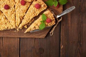 morceaux triangulaires tranchés de tarte crumble aux pommes sur une planche en bois marron photo