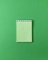 ouvrir un petit cahier vide sur fond vert photo