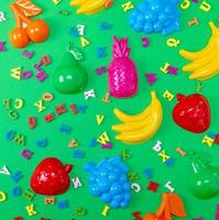 fond vert avec des jouets en plastique pour enfants et des lettres multicolores en bois photo