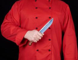 chef en uniforme rouge tenant un couteau de cuisine photo
