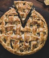 toute la tarte aux pommes ronde cuite sur une planche de bois marron photo