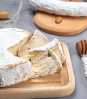fromage brie rond sur une planche à découper en bois