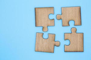 puzzle en bois sur fond bleu. puzzle en bois sur fond bleu. concept d'entreprise d'équipe photo