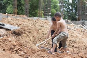 deux enfants ont été forcés de travailler dans la construction à cause de la pauvreté. enfants violents et concept de traite, lutte contre le travail des enfants, journée des droits le 10 décembre. photo