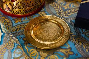 anneaux de mariage dorés sur plaque de métal à l'église avec eau bénite. cérémonie traditionnelle de mariage. espace pour le texte photo