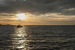 navire sur la mer au coucher du soleil photo