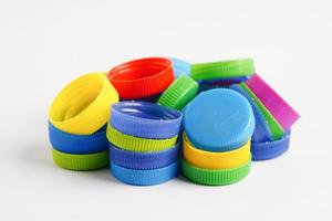 bouchons de bouteilles en plastique colorés pour recyclage sur fond blanc. photo