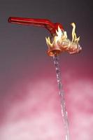 L'eau qui coule du robinet avec flammes et levier rouge sur fond rouge