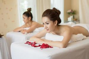 belle femme souriante avec des fleurs au repos dans le spa avant le massage photo