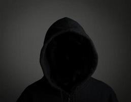 Jeune hacker pas de visage sur fond noir photo