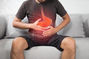 reflux acide ou brûlures d'estomac, la photo de l'estomac est sur le corps des hommes sur fond gris, mauvaise santé, concept d'anatomie masculine