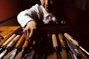 une jeune luthière chinoise choisit des outils appropriés pour fabriquer le violon photo
