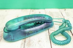 téléphone vintage coloré émeraude sur une table en bois blanc photo