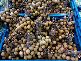 fruit longane dans un panier bleu prêt à être vendu à maket photo