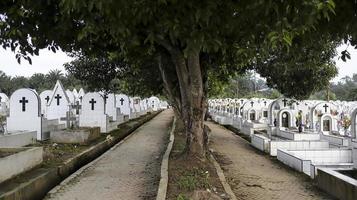 le chemin du cimetière public contient des tombes en céramique blanche identiques à gauche et à droite. photo